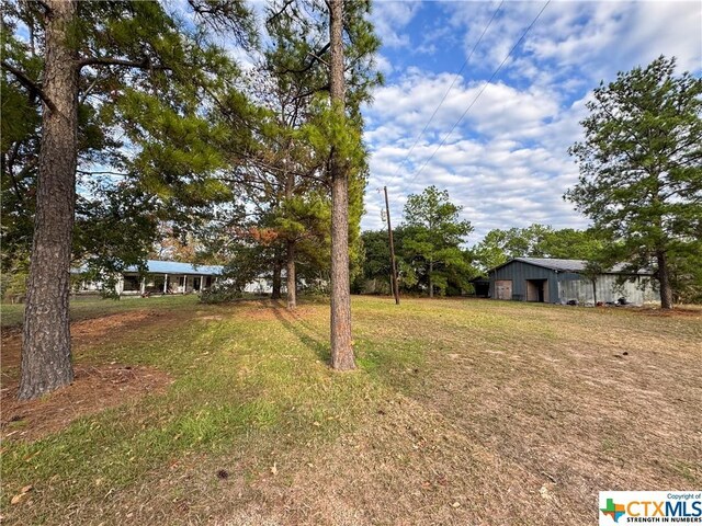 21 Anderson Ln, Coldspring, TX 77331 - view of grassy yard featuring a garage, a pole building, and an outdoor structure