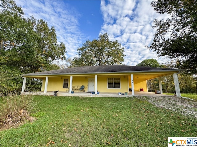 rear view of property with a porch, a yard, and a carport