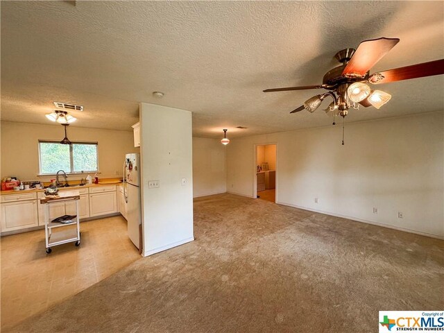 21 Anderson Ln, Coldspring, TX 77331 - unfurnished living room featuring a sink, ceiling fan, a textured ceiling, light carpet, and baseboards