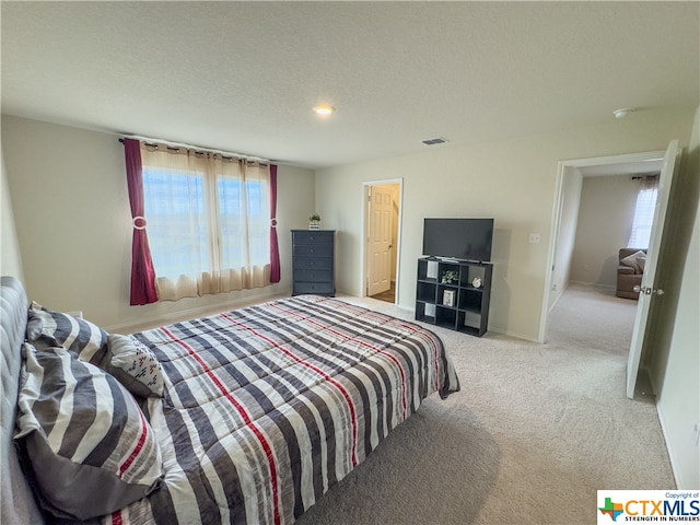 carpeted bedroom featuring a textured ceiling