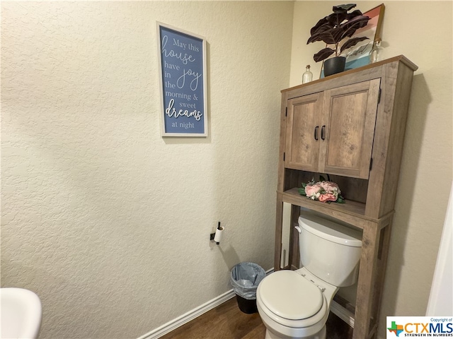 bathroom with toilet and hardwood / wood-style flooring