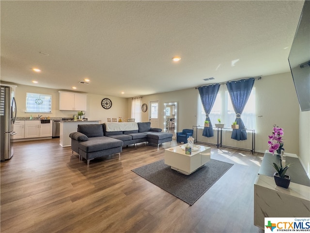 living room with hardwood / wood-style floors and a textured ceiling