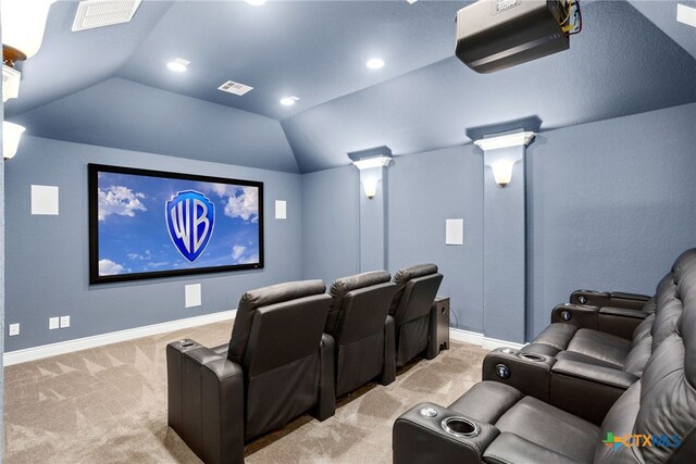 home theater with lofted ceiling, light colored carpet, and ornate columns