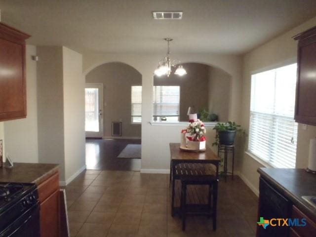 dining room featuring dark tile patterned flooring and a chandelier