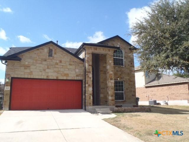 view of front of house with a garage and central air condition unit