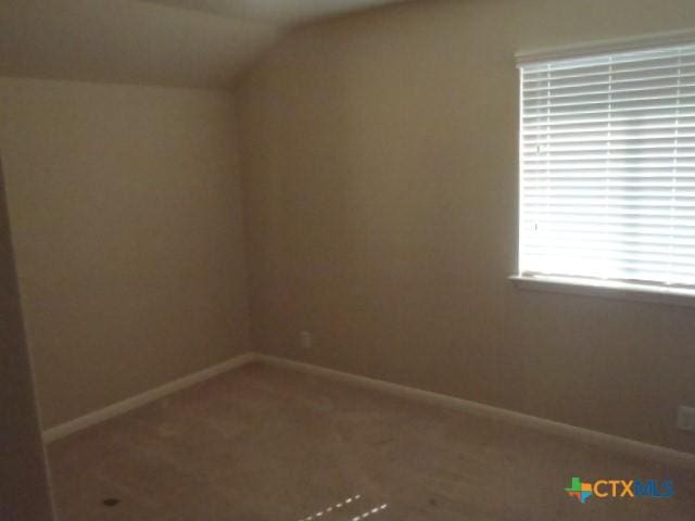 spare room featuring vaulted ceiling