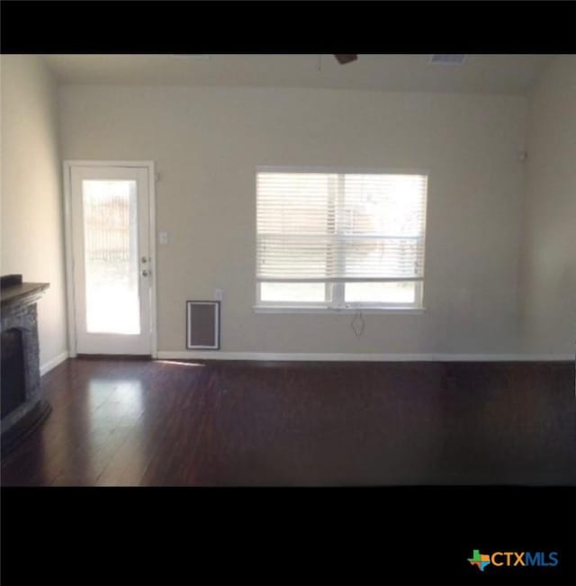 unfurnished living room featuring dark hardwood / wood-style floors