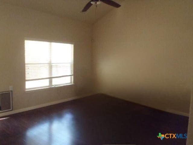 unfurnished room featuring lofted ceiling, dark hardwood / wood-style flooring, and ceiling fan