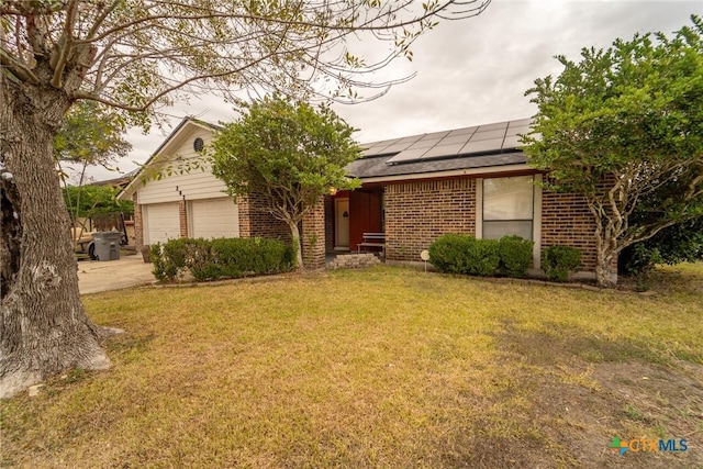 view of front of house featuring a front lawn, a garage, and solar panels