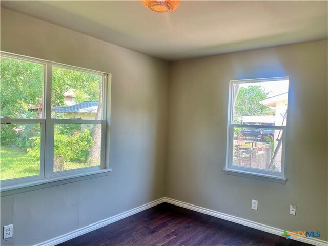 413 Vickers Ave, Seguin, TX 78155 - empty room featuring healthy amount of natural light, baseboards, and dark wood finished floors