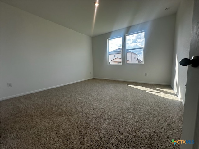 spare room with carpet flooring and vaulted ceiling