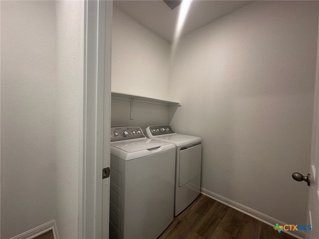 washroom with washing machine and dryer and dark hardwood / wood-style flooring