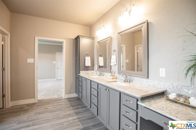 1014 Winchester Dr, Nolanville, TX 76559 - bathroom featuring wood finished floors, double vanity, and baseboards
