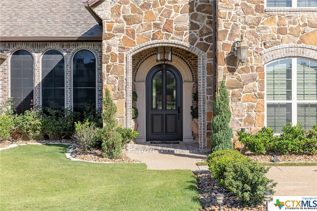 view of exterior entry with a yard