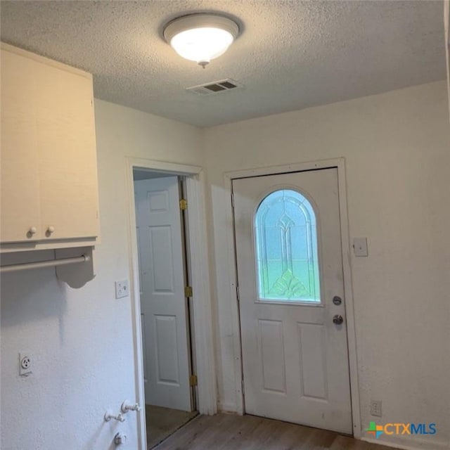 entryway featuring hardwood / wood-style flooring and a textured ceiling