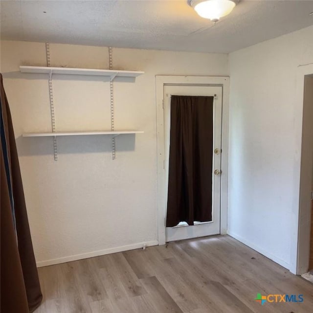 empty room featuring wood-type flooring and a textured ceiling