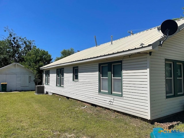 view of home's exterior with a lawn, cooling unit, and a storage shed