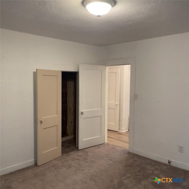 unfurnished bedroom with carpet flooring and a textured ceiling