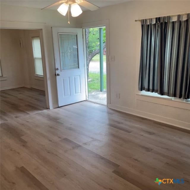 foyer with ceiling fan and wood-type flooring