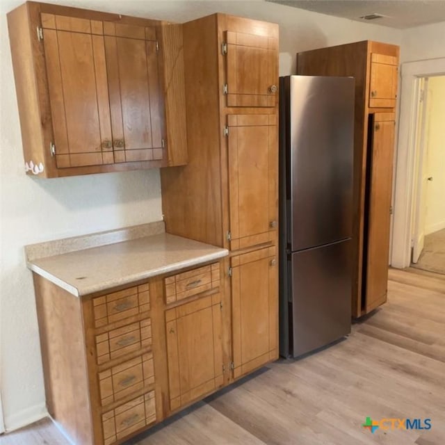 kitchen featuring light hardwood / wood-style floors and stainless steel refrigerator