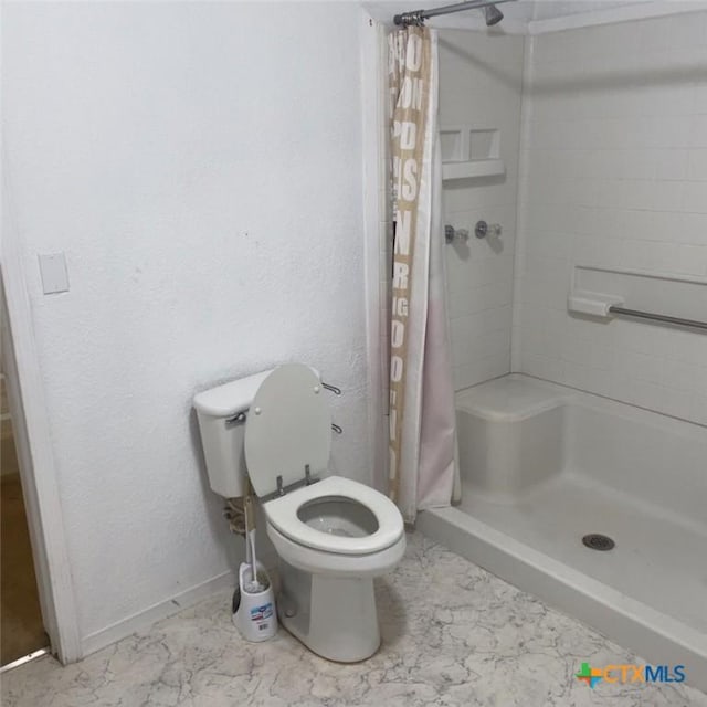 bathroom featuring curtained shower and toilet