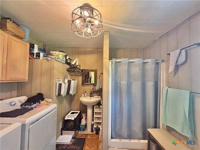1208 W Adams St, Port Oconnor, TX 77982 - bathroom featuring washer and dryer, a shower stall, and wood walls