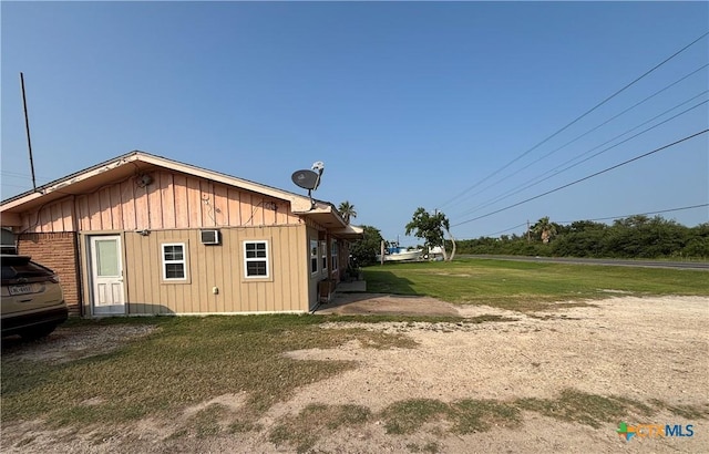 1208 W Adams St, Port Oconnor, TX 77982 - view of property exterior featuring a lawn and board and batten siding