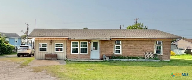 1208 W Adams St, Port Oconnor, TX 77982 - view of front of house featuring board and batten siding and a front yard