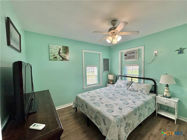 1208 W Adams St, Port Oconnor, TX 77982 - bedroom with a wall unit AC, dark wood-type flooring, electric panel, and a ceiling fan