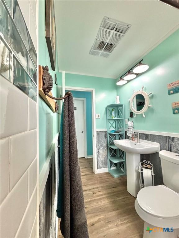 1208 W Adams St, Port Oconnor, TX 77982 - half bathroom with a wainscoted wall and wood finished floors