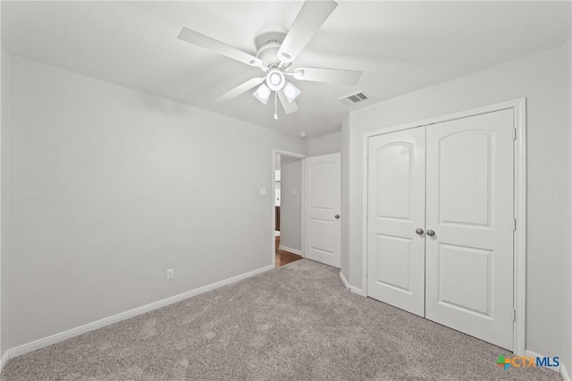 unfurnished bedroom with ceiling fan, light colored carpet, and a closet