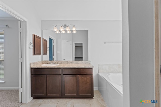 bathroom with tile patterned floors, vanity, and a tub