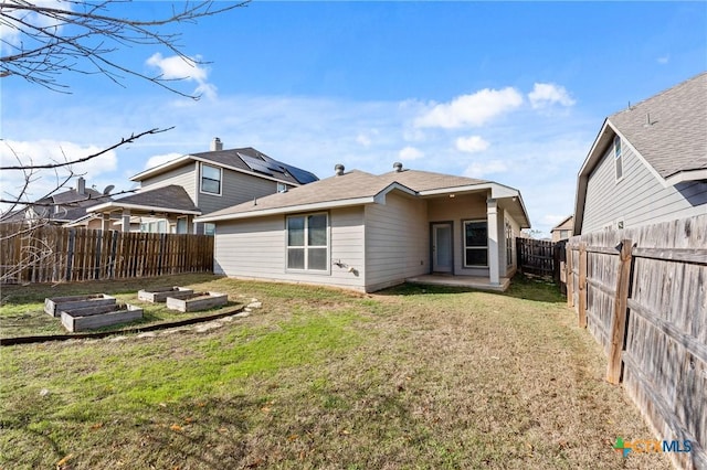 rear view of house featuring a yard