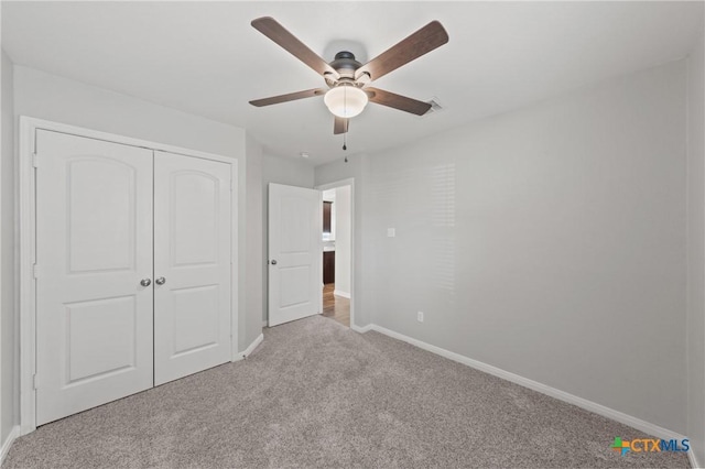 unfurnished bedroom featuring ceiling fan, light colored carpet, and a closet