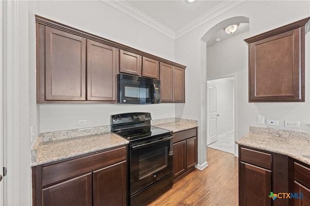 kitchen featuring black appliances, light stone countertops, light wood-type flooring, ornamental molding, and dark brown cabinetry