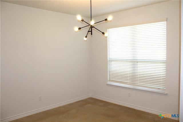 unfurnished room featuring carpet, a chandelier, and a healthy amount of sunlight