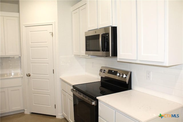 kitchen featuring decorative backsplash, white cabinets, and stainless steel appliances