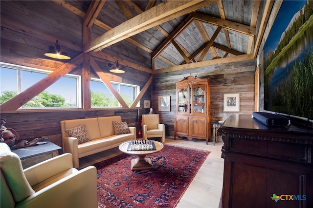 living room with high vaulted ceiling, wooden walls, wooden ceiling, and beam ceiling