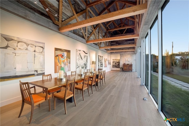 dining area with high vaulted ceiling, beamed ceiling, and wood-type flooring