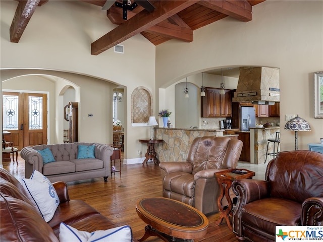 living room featuring beamed ceiling, high vaulted ceiling, and hardwood / wood-style floors