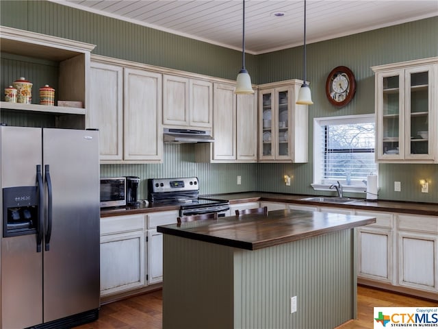 kitchen featuring sink, hanging light fixtures, stainless steel appliances, light hardwood / wood-style floors, and a kitchen island