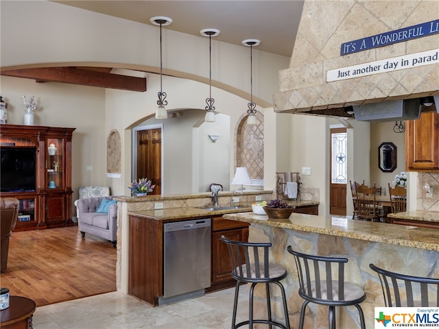 kitchen with sink, dishwasher, light stone countertops, decorative backsplash, and decorative light fixtures