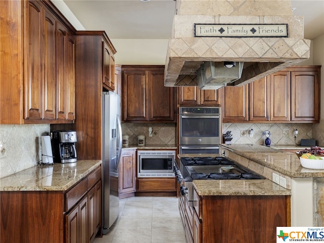 kitchen featuring stainless steel appliances, extractor fan, light stone countertops, and backsplash