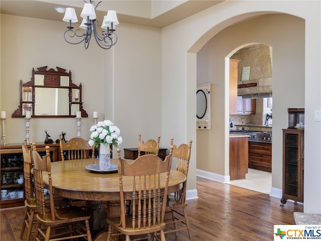 dining space with hardwood / wood-style floors, a notable chandelier, and beverage cooler