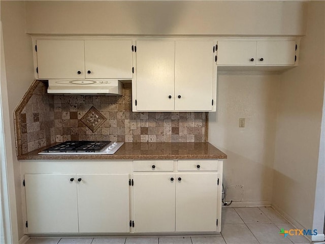 kitchen featuring backsplash, exhaust hood, stainless steel gas stovetop, and white cabinetry