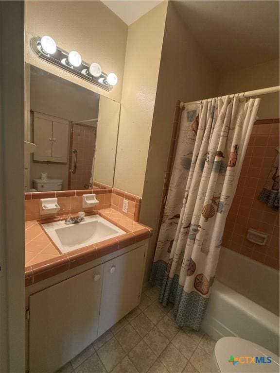 full bathroom featuring toilet, vanity, and shower / bath combo with shower curtain