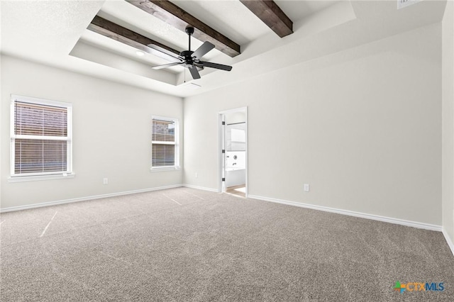 unfurnished bedroom featuring beam ceiling, light colored carpet, a raised ceiling, and ceiling fan