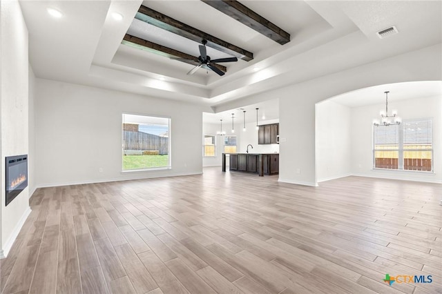 unfurnished living room featuring light wood-type flooring, a large fireplace, and plenty of natural light