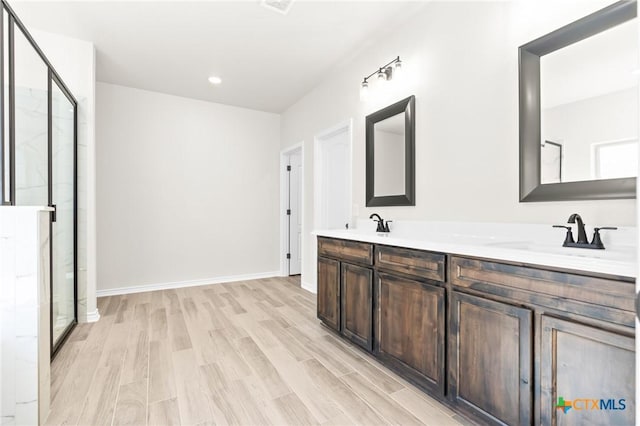 bathroom with hardwood / wood-style floors, vanity, and walk in shower