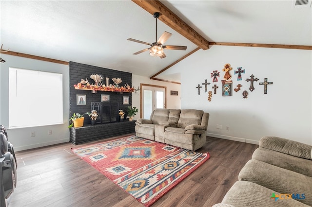 living room with dark hardwood / wood-style flooring, ceiling fan, lofted ceiling with beams, and a brick fireplace